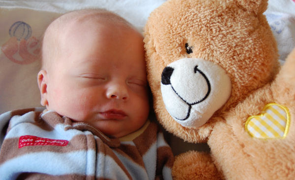 Schlafendes Baby neben Teddybär